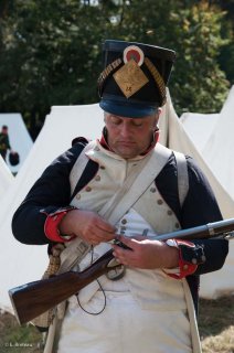 Reconstitution d'un bivouac des troupes napoléoniennes au château du Passage en Isère. Un soldat change le silex de son fusil