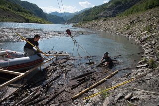 Lac du Chambon. Une équipe de débardeurs par câble sort les bois flottés du lac