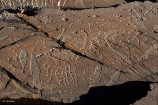 Sur cette dalle, les principales figures de gravures rupestres de la Vallée des Merveilles sont représentées : Poignards, réticulés et corniformes.