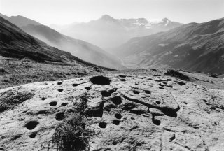 Savoie. Pierre à cupules de l'Arcelle Neuve. Au fond la Dent Parrachée.